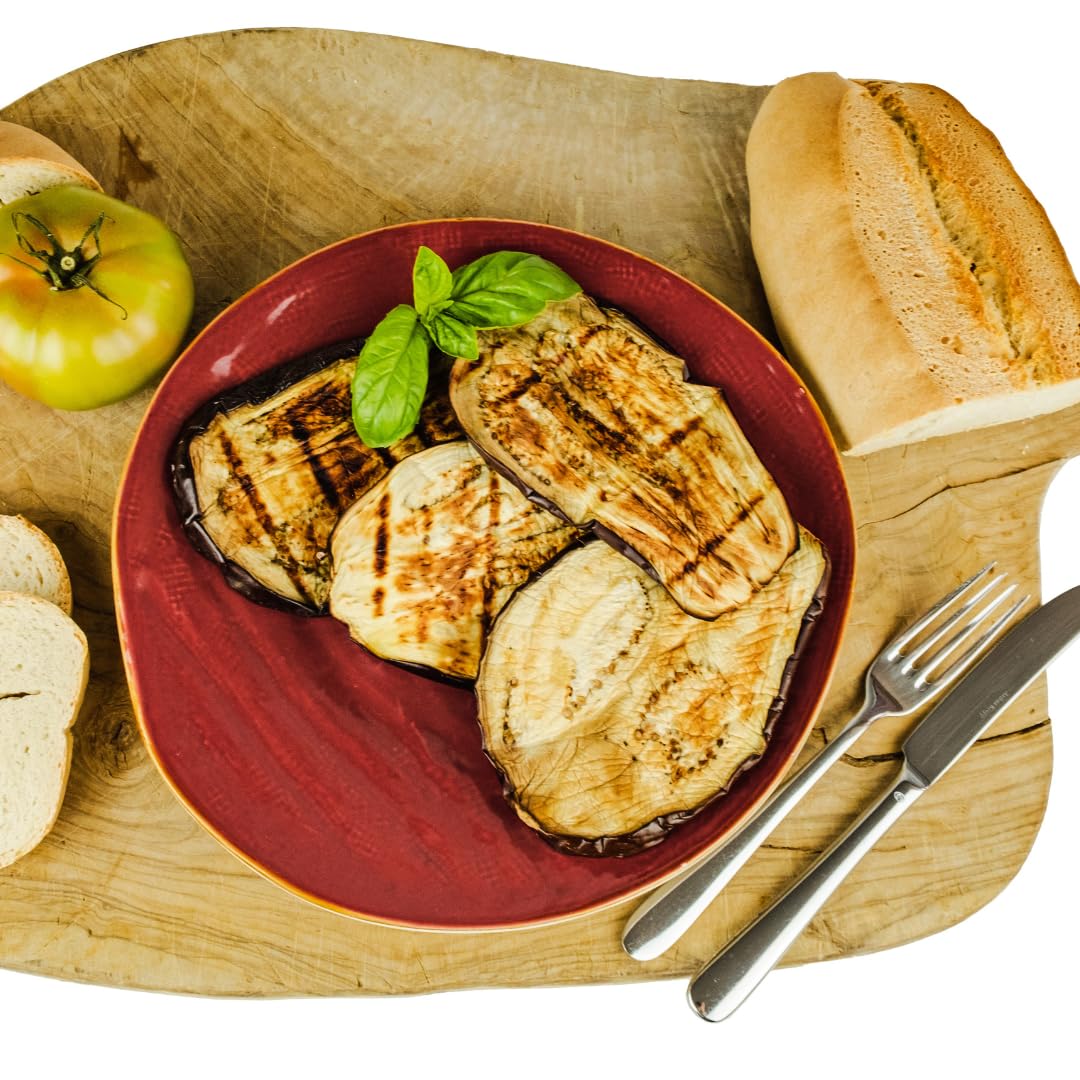 Grilled eggplant slices on a red plate with bread and a tomato on a wooden board.