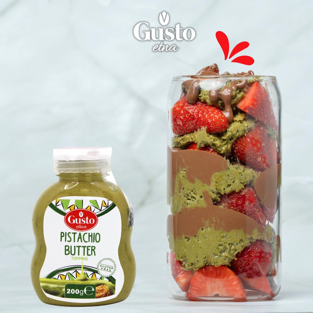 Gusto Etna Pistachio Butter topping bottle next to dessert jar layered with fresh strawberries, pistachio cream, and chocolate drizzle
