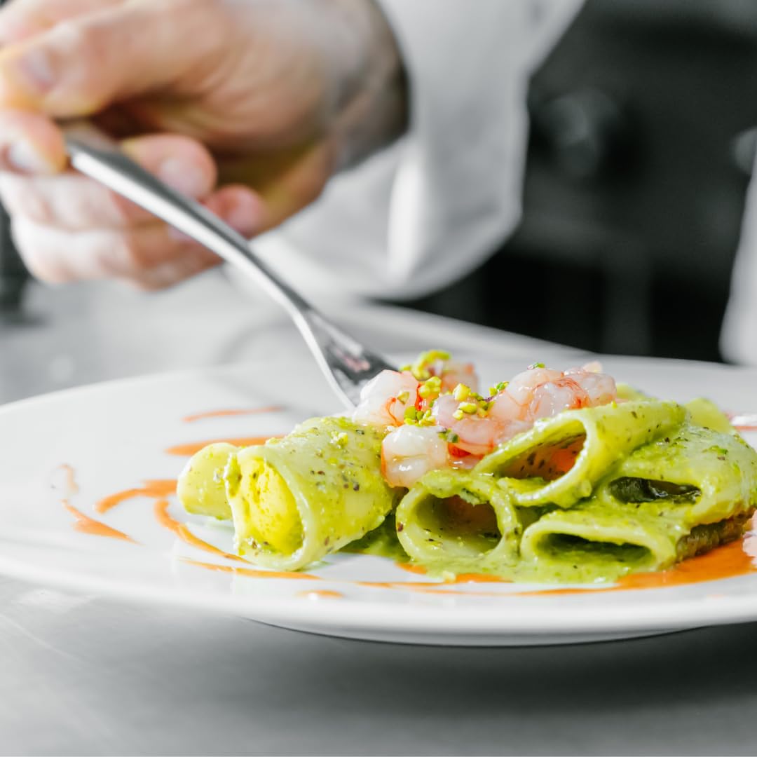 Gourmet paccheri pasta served with creamy pistachio pesto and topped with fresh shrimp.