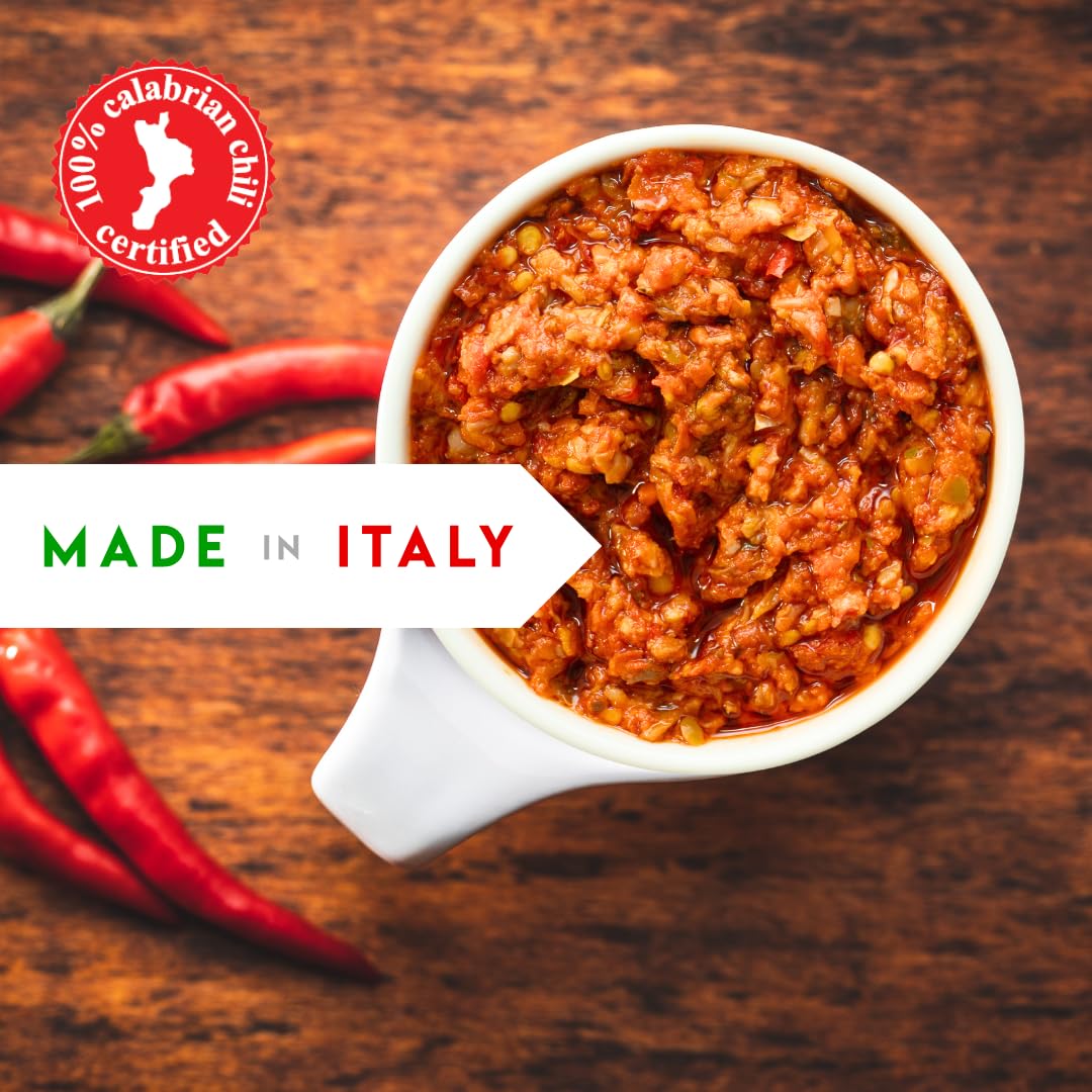 White bowl of red chili paste with red peppers on a wooden surface, featuring '100% Calabrian Chili Certified' and 'Made in Italy' text.