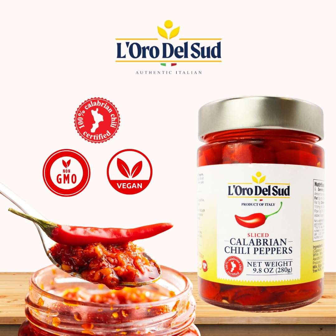 Jar of L'Oro Del Sud Calabrian chili peppers with a spoonful of chili paste on a white background.
