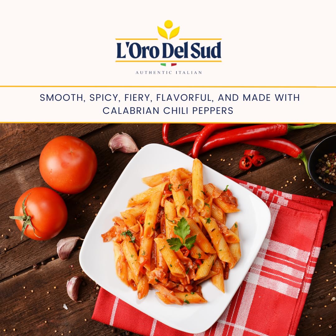 Plate of pasta with tomatoes and chili peppers on a wooden table, featuring L'Oro Del Sud branding.