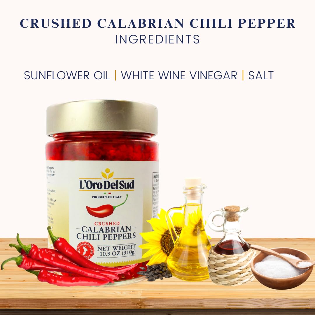 Jar of L'Oro Del Sud crushed Calabrian chili peppers with ingredients on a wooden board.