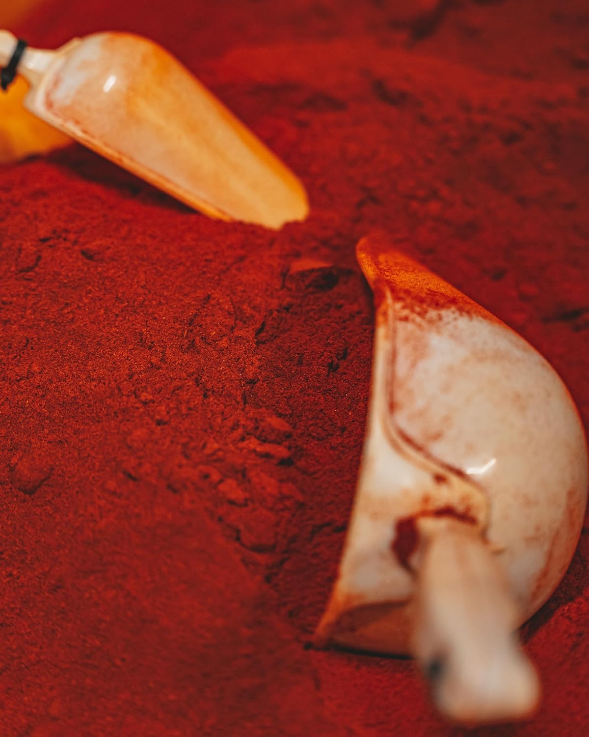 Close-up of a red powder with a scoop on a red background