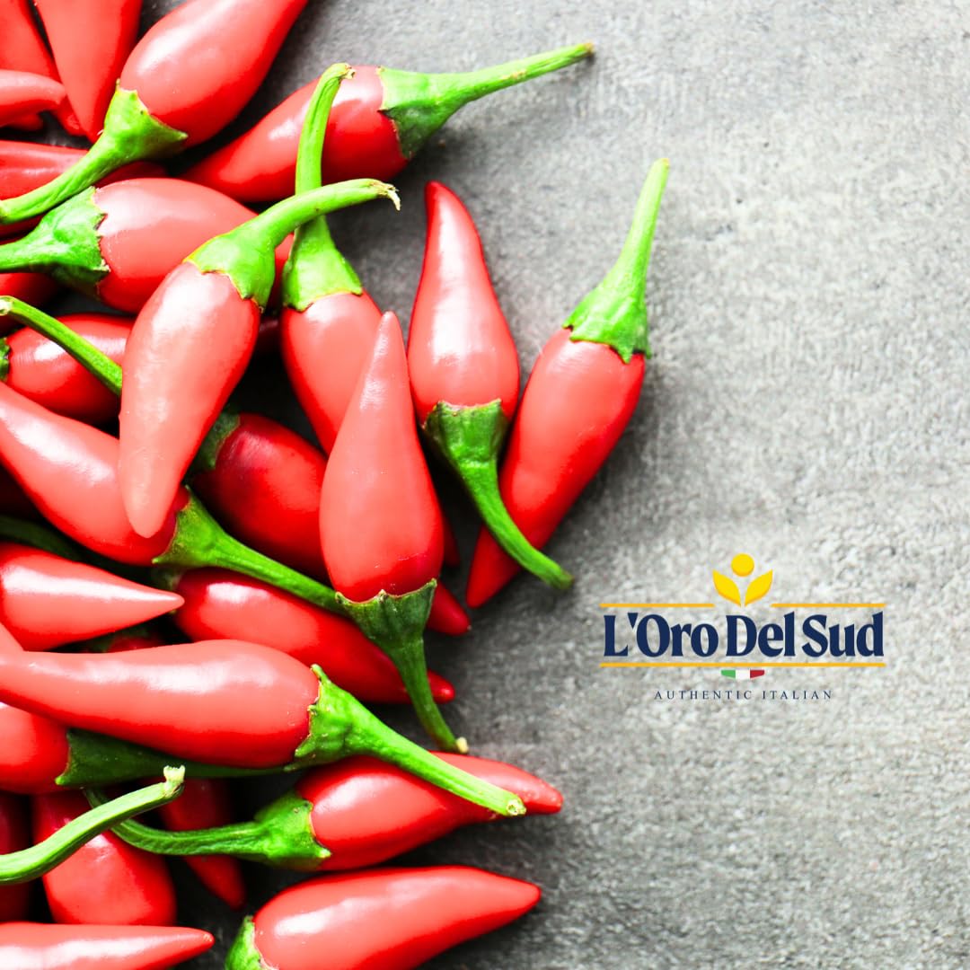 Red chili peppers on a gray surface with L'Oro Del Sud logo.