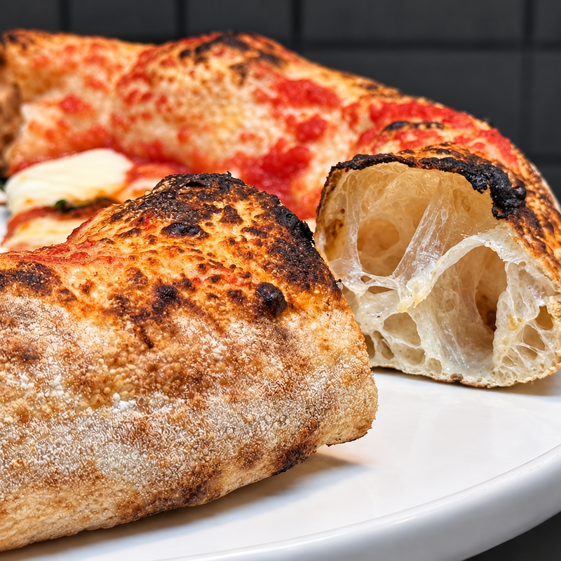 Contemporary Neapolitan pizza crust cut open to show a light, airy crumb with big bubbles