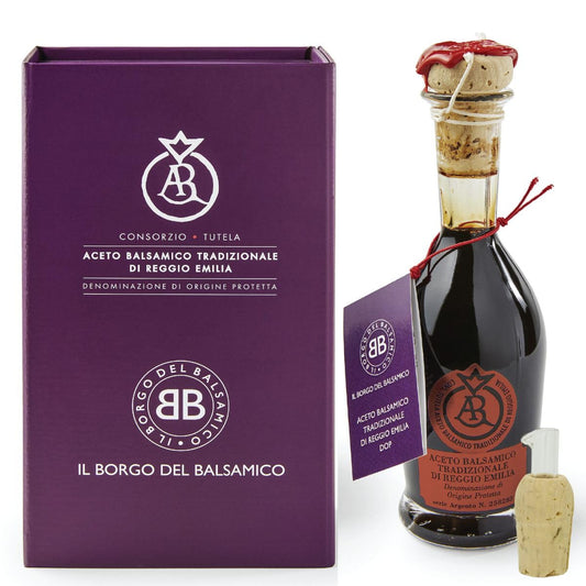 Balsamic vinegar bottle with cork and packaging on a white background