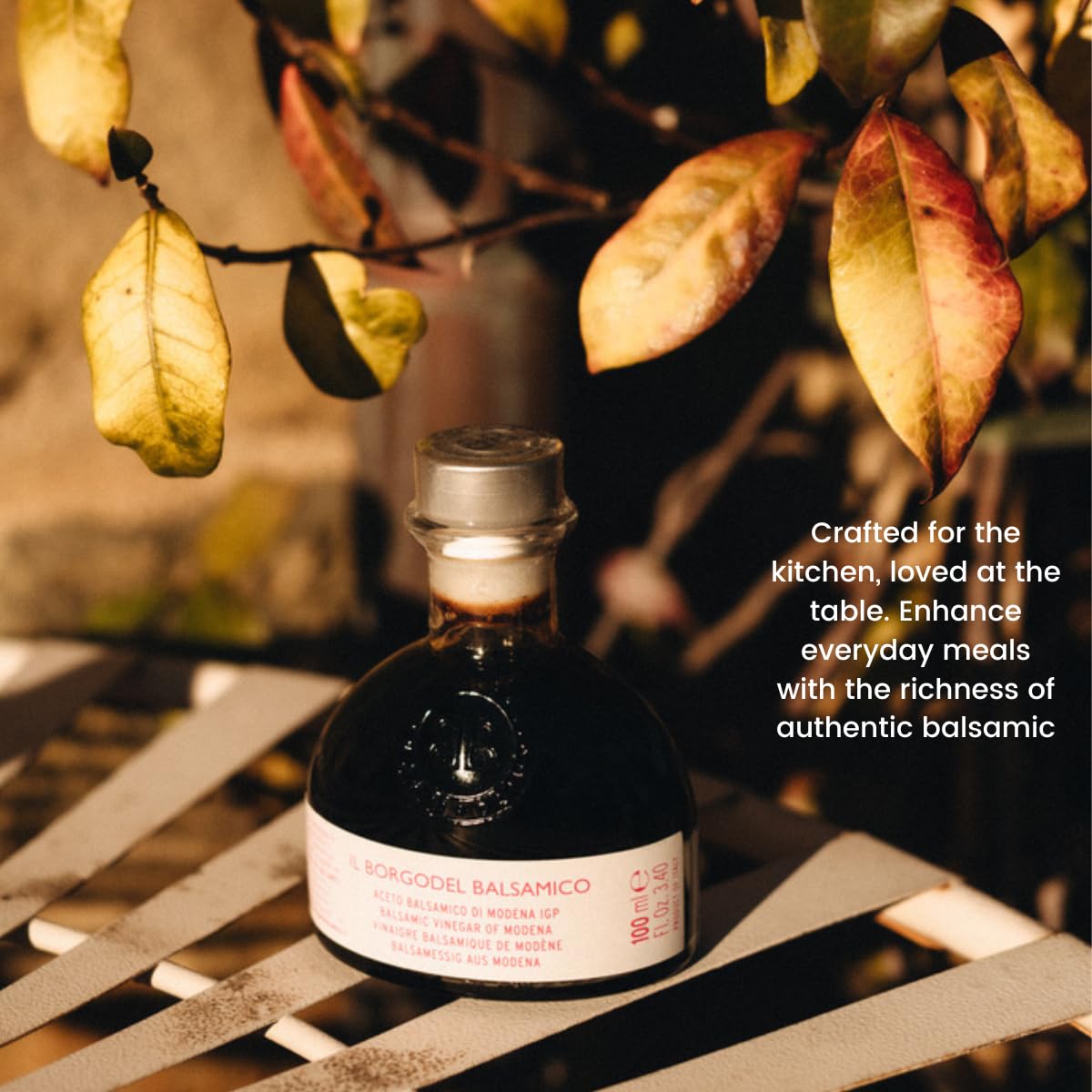 Bottle of balsamic vinegar on a wooden surface with autumn leaves in the background