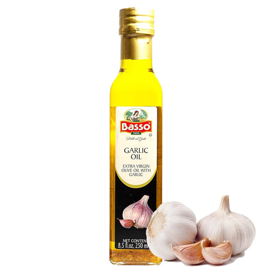 Botella de aceite de oliva extra virgen infusionado con ajo Basso 1904 de 250 ml, con bulbos de ajo fresco en primer plano. Producto gourmet italiano ideal para pastas, vegetales, carnes, marinados y pan, no GMO, vegano y sin gluten.