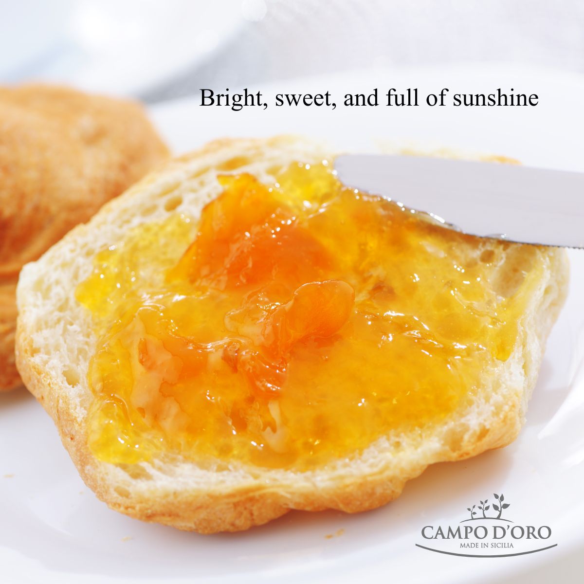 Bread slice with yellow jam being spread, with 'Campo d'Oro' branding.