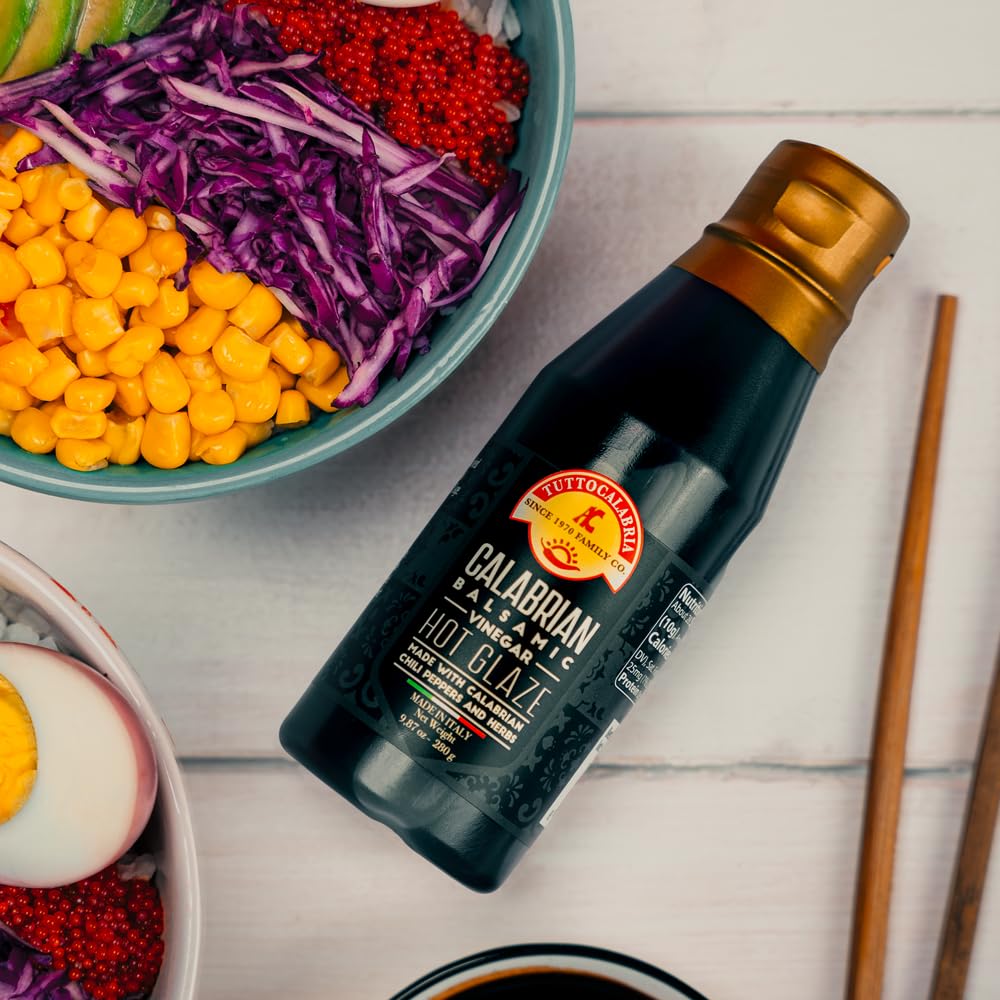Bottle of Calabrian Hot Glaze with a bowl of salad in the background