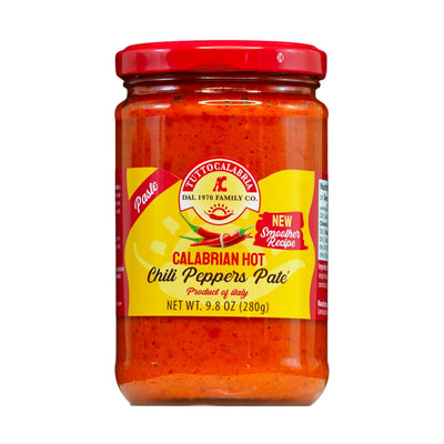 Jar of Calabrian hot chili peppers pate with a red lid on a white background