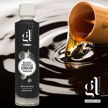 Bottle of GL Truffle Black Truffle Drop Vinegar beside a bamboo ladle pouring vinegar into dark liquid.