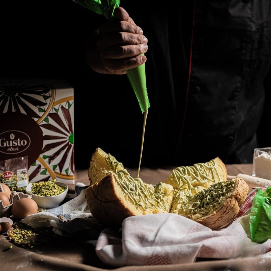 Spreading creamy Sicilian pistachio spread on artisan bread