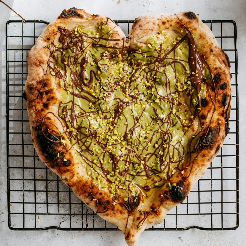 Gourmet pistachio dessert pizza topped with pistachio cream