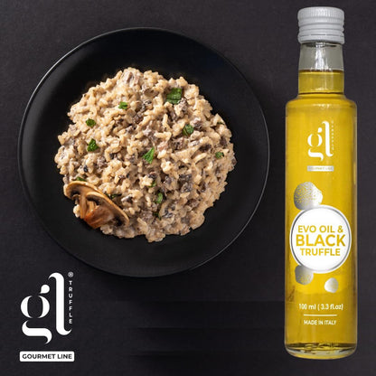 Risotto with mushrooms on a black plate next to a bottle of Gourmet Line truffle oil.