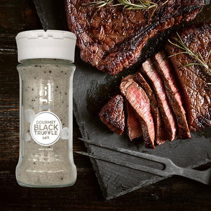 Bottle of Gourmet Black Truffle Salt next to sliced steak on a wooden surface