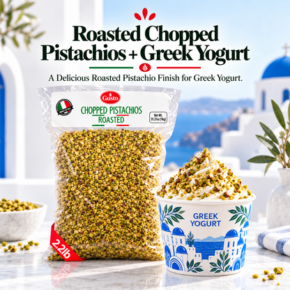 A bag of Gusto Etna Roasted Chopped Pistachios next to a blue and white Greek Yogurt cup topped with chopped pistachios, set against a blurred Santorini-style background with white buildings and blue domes.