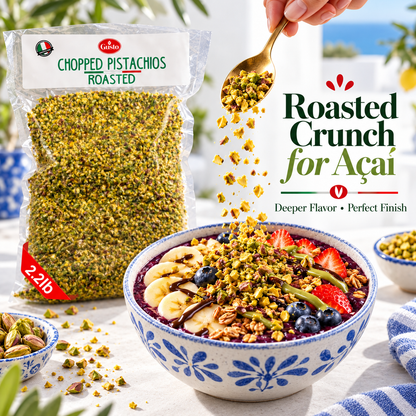 A bag of Libero Chopped Pistachios Roasted is shown next to a blue-and-white bowl topped with granola, banana, blueberries, strawberries, and a spoonful of pistachio crumbs being sprinkled over the dish. Promotional text reads 'Roasted Crunch for Açaí'.