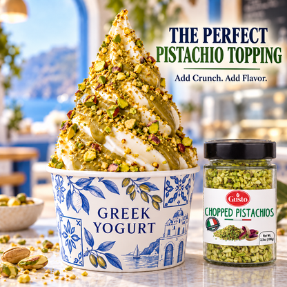 A swirl of Greek yogurt topped with chopped pistachio and nuts sits in a blue-and-white patterned cup, with a jar of Guisto Chopped Pistachios beside it and promotional text reading 'The Perfect Pistachio Topping.'.