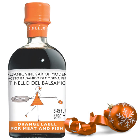 Balsamic vinegar bottle with orange cap and label on a white background