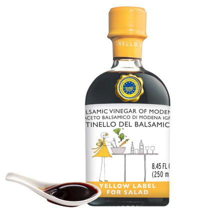 Bottle of balsamic vinegar with a yellow label on a white background
