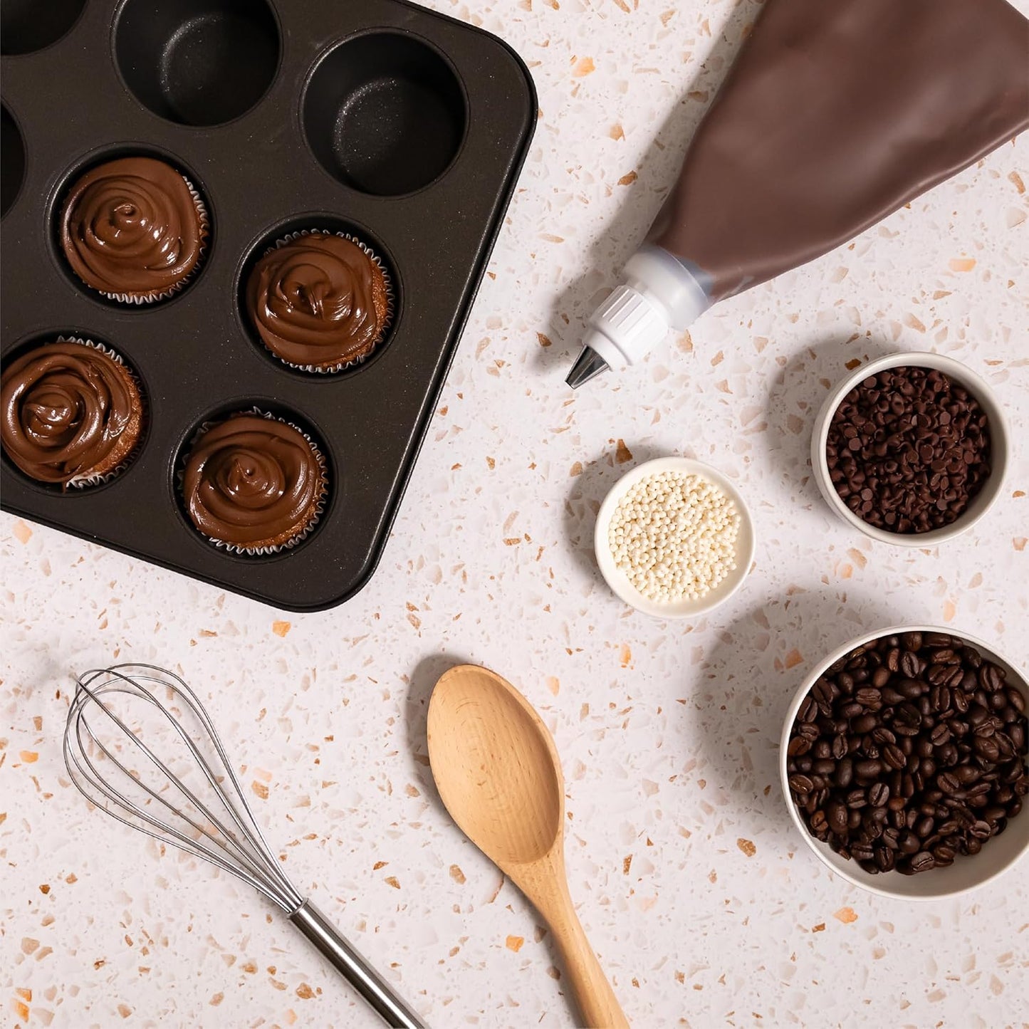 muffin-pan-with-chocolate-hazelnut-espresso-frosting-piping-bag-coffee-beans-and-baking-tools