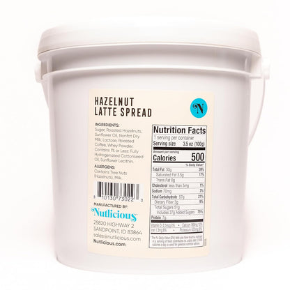 Back view of Nutlicious Hazelnut Latte Spread 9 lb tub showing nutrition facts, ingredient list (sugar, roasted hazelnuts, sunflower oil, nonfat dry milk, lactose, roasted coffee, whey powder), allergen information, barcode, and manufacturer details.