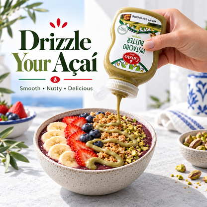 A hand holds a squeeze bottle of Pistachio Butter spread over a colorful smoothie bowl topped with sliced bananas, strawberries, blueberries, and crushed pistachios. Large text on the left reads 'Drizzle Your Açaí' with smaller copy 'Smooth • Nutty • Delicious.