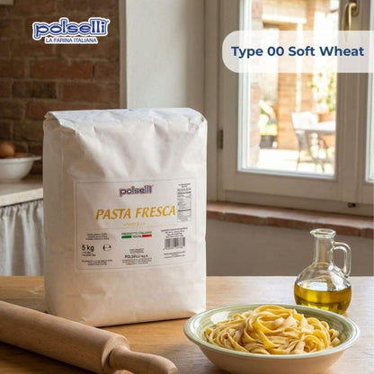 A 5 kg bag of Pelselli Pasta Fresca Type 00 Soft Wheat flour stands on a wooden table in a kitchen setting, with a bowl of fresh pasta, a rolling pin, and a bottle of olive oil nearby. The Pelselli brand logo is visible in the top left, and a text overlay reads 'Type 00 Soft Wheat'.