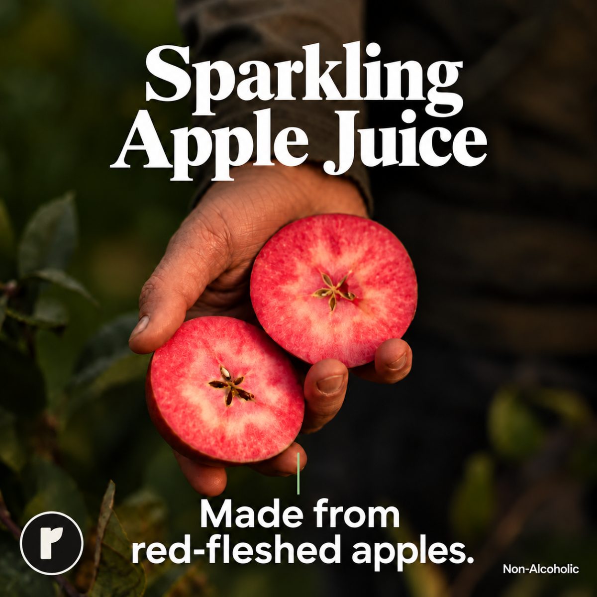 A hand holds two cut red apples against a dark outdoor background with leaves. Large white text reads 'Sparkling Apple Juice,' with smaller text below saying 'Made from red-fleshed apples.