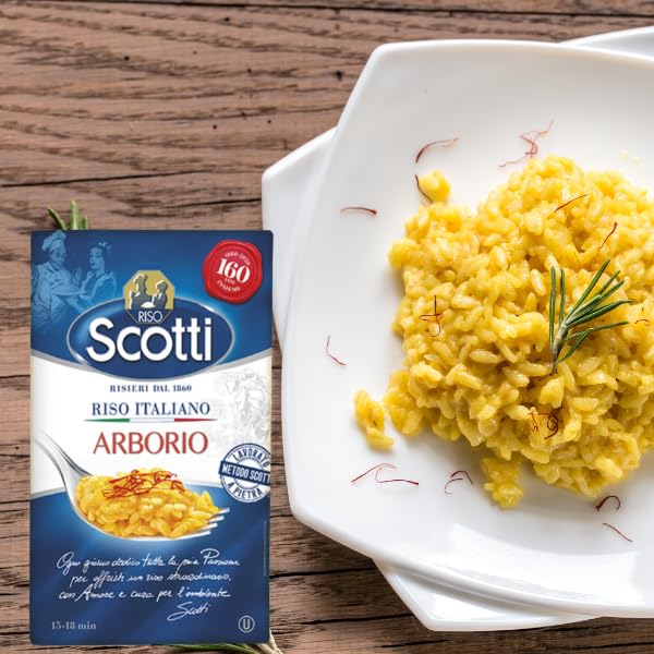 Riso Scotti Arborio Rice package displayed next to a plate of creamy saffron risotto garnished with rosemary on a rustic wooden table.
