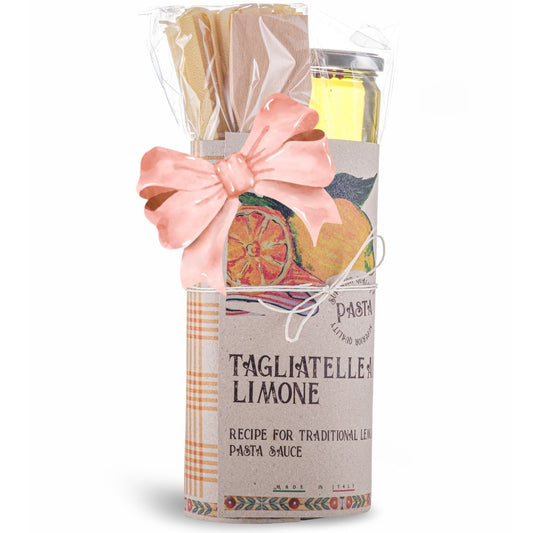Pasta gift set with tagliatelle limone, a candle, and a small bag on a white background