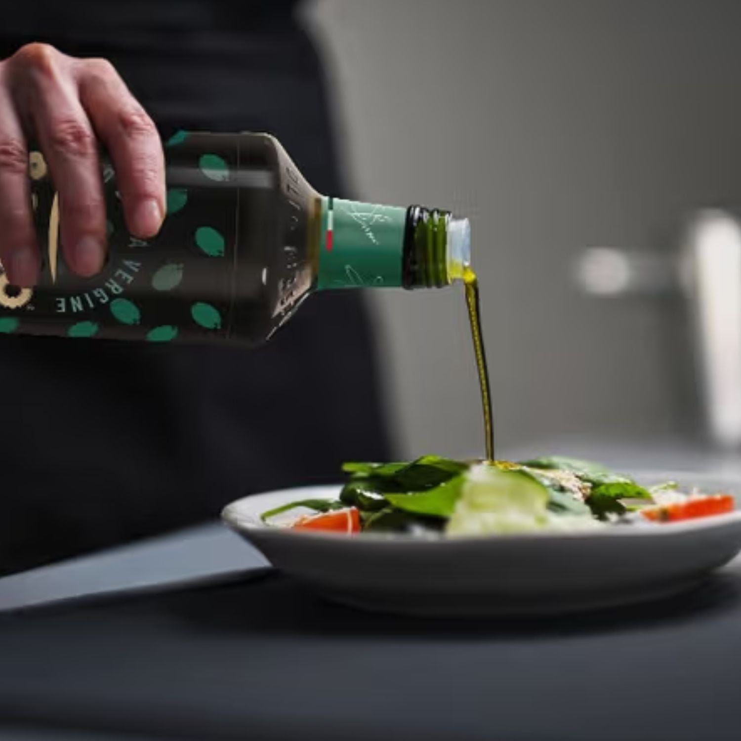 Basso extra virgin olive oil being poured over a fresh salad.