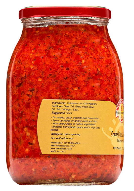 Jar of red pepper spread with a label on a white background