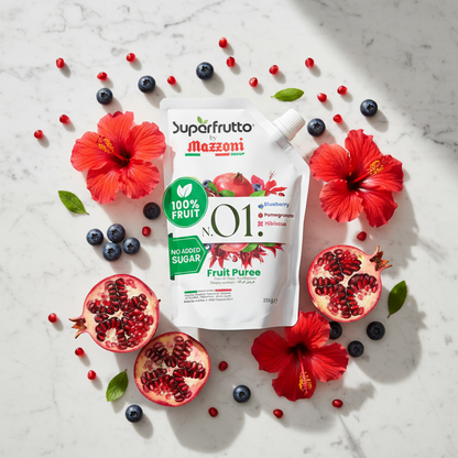Flat lay of Superfrutto by Mazzoni N.01 pouch with fresh pomegranate, blueberries and hibiscus flowers