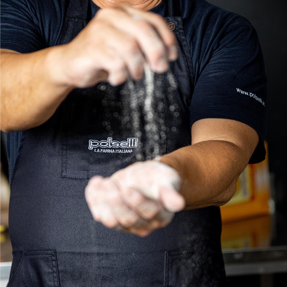 Italian baker dusting Polselli flour during dough preparation