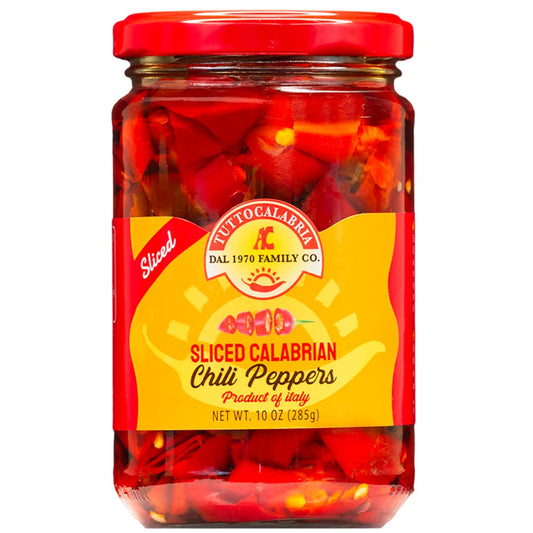 Jar of sliced Calabrian chili peppers with a red lid and yellow label on a white background.