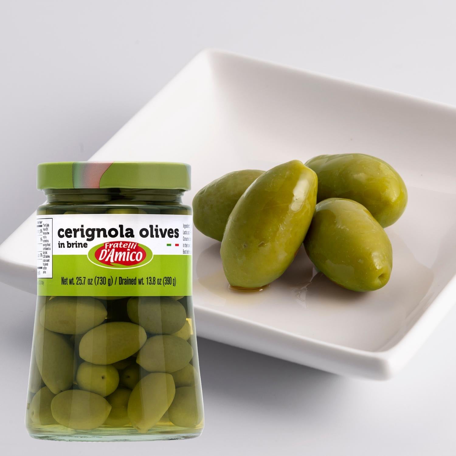 Jar of Fratelli D’Amico Green Cerignola Olives in brine (25.7 oz / 730 g) placed next to a white dish with several large, glossy green olives, highlighting their size and fresh texture.