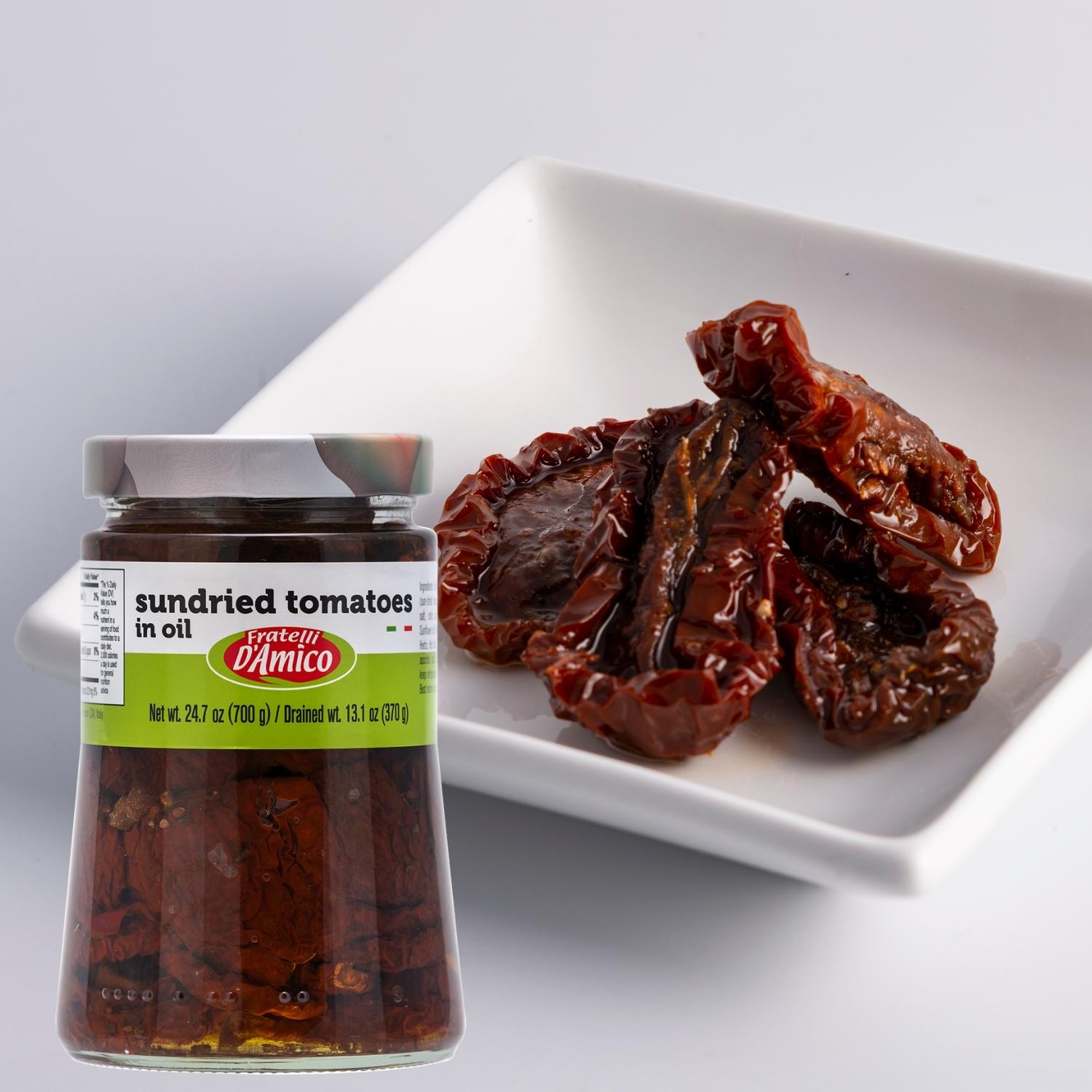 Fratelli D’Amico Sun-Dried Tomatoes in Oil, 24.7 oz (700 g) jar with drained weight of 13.1 oz (370 g), displayed next to a white dish holding several glossy sun-dried tomato halves